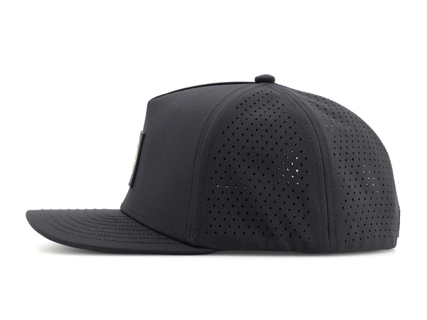 Black colored Rover premium performance fitted hat from Hatchet Headwear pictured with a white foreground and background. The hat is positioned at an approximately 90 degree angle to showcase the left-side profile of the hat. The diamond shaped laser perforations of the hat designed to provide breathability and reduce heat retention are prominently featured.