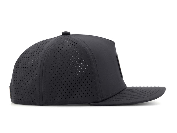 Black colored Rover premium performance fitted hat from Hatchet Headwear pictured with a white foreground and background. The hat is positioned at an approximately 90 degree angle to showcase the right-side profile of the hat. The diamond shaped laser perforations of the hat designed to provide breathability and reduce heat retention are prominently featured.