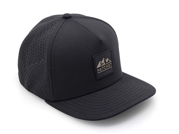Black colored Rover premium performance fitted hat from Hatchet Headwear pictured with a white foreground and background. Hat features a color matched Black rubber logo patch with the Hatchet Headwear logo (mountains, tent, and hatchet above the word "HATCHET) in taupe. The hat is positioned at an approximately 45 degree angle to showcase the front and right-side profile of the hat. Image perspective of the hat is taken such that the hat is photographed from above.