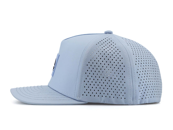 Glacier colored Rover premium performance fitted hat from Hatchet Headwear pictured with a white foreground and background. The hat is positioned at an approximately 90 degree angle to showcase the left-side profile of the hat. The diamond shaped laser perforations of the hat designed to provide breathability and reduce heat retention are prominently featured.