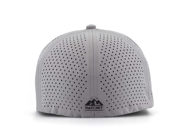 Smoke colored Rover premium performance fitted hat from Hatchet Headwear pictured with a white foreground and background. Hat features a color matched Smoke rear rubber logo patch with the Hatchet Headwear logo (mountains, tent, and hatchet above the word "HATCHET) in black. The hat is photographed from the rear to depict the fitted nature of the hat and stylish Hatchet Headwear logo on the back of the hat. Also prominently featured are the diamond shaped laser perforations for breathability.