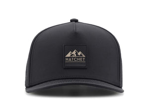 Black colored Rover premium performance fitted hat from Hatchet Headwear pictured with a white foreground and background.  Hat features a color matched Black rubber logo patch with the Hatchet Headwear logo (mountains, tent, and  hatchet above the word "HATCHET) in taupe.  The hat is pictured from the front and facing directly at the camera.