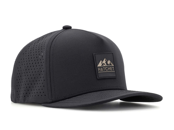 Black colored Rover premium performance fitted hat from Hatchet Headwear pictured with a white foreground and background.  Hat features a color matched Black rubber logo patch with the Hatchet Headwear logo (mountains, tent, and  hatchet above the word "HATCHET) in taupe.  The hat is positioned at an approximately 45 degree angle to showcase the front and right-side profile of the hat.
