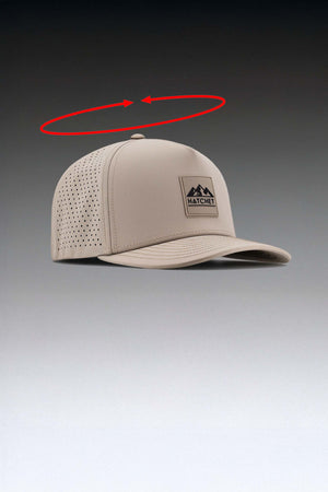 Boulder colored Rover premium performance fitted hat  positioned at an approximately 45 degree angle.  Above the hat is a red open circle above the hat.  At both sides of the circle's opening are arrows.  The opened circle with arrows is intended to depict how the circumference of the hat is measured.  The hat is sitting in front of a gray gradient background.