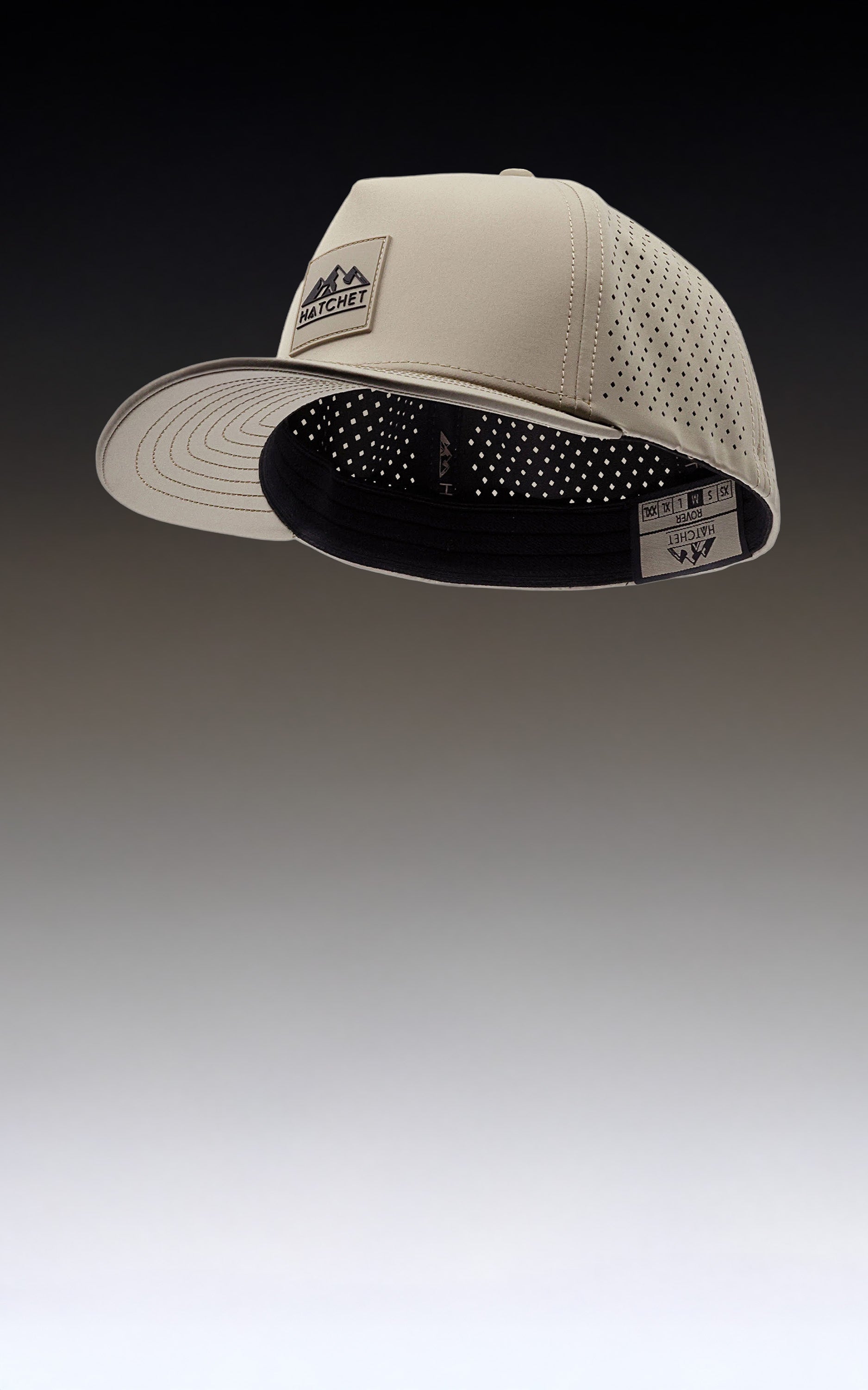 Boulder colored Rover premium performance fitted hat from Hatchet Headwear featured on a gradient gray background.  Interior woven label of the Rover hat is visible and details the six available custom tailored fitted hat sizes (XS, S, M, L, XL, and XXL).