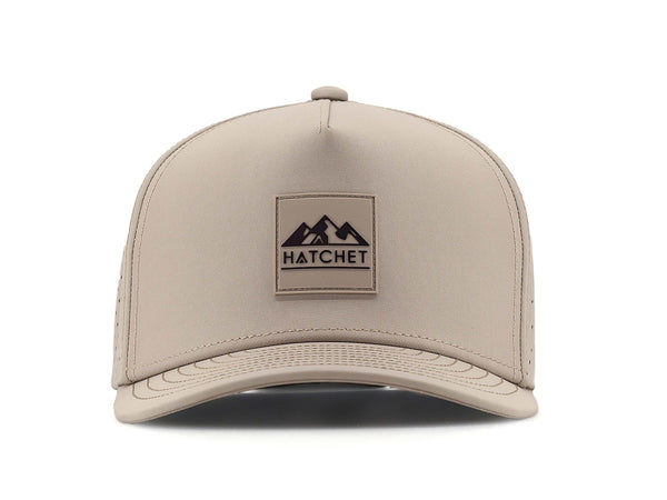 Boulder colored Rover premium performance fitted hat from Hatchet Headwear pictured with a white foreground and background.  Hat features a color matched Boulder rubber logo patch with the Hatchet Headwear logo (mountains, tent, and  hatchet above the word "HATCHET) in black.  The hat is pictured from the front and facing directly at the camera.