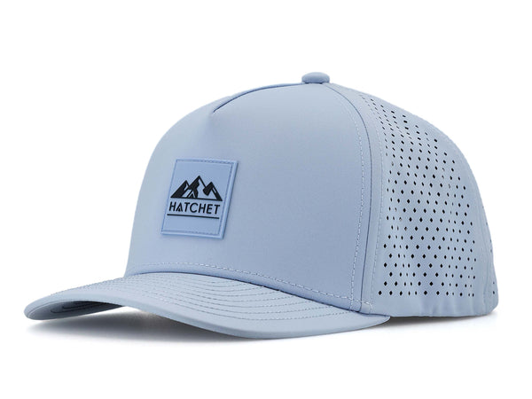 Glacier colored Rover premium performance fitted hat from Hatchet Headwear pictured with a white foreground and background.  Hat features a color matched Glacier rubber logo patch with the Hatchet Headwear logo (mountains, tent, and  hatchet above the word "HATCHET) in slate blue.  The hat is positioned at an approximately 45 degree angle to showcase the front and left-side profile of the hat.