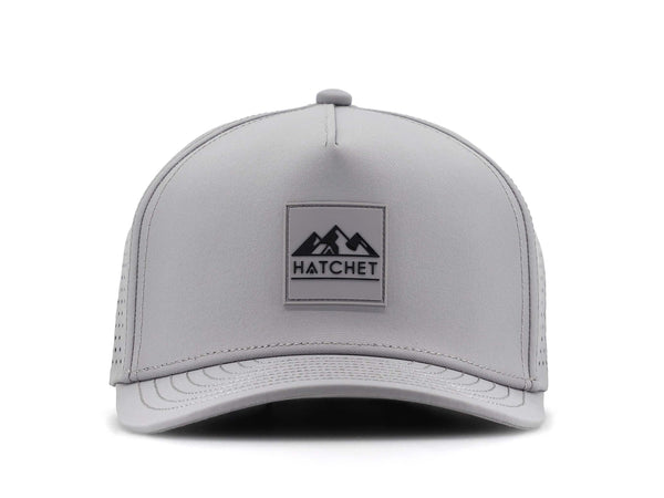 Smoke colored Rover premium performance fitted hat from Hatchet Headwear pictured with a white foreground and background.  Hat features a color matched Smoke rubber logo patch with the Hatchet Headwear logo (mountains, tent, and  hatchet above the word "HATCHET) in black.  The hat is pictured from the front and facing directly at the camera.
