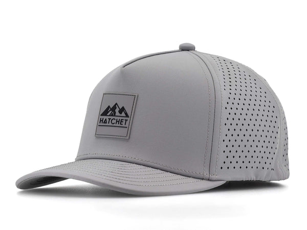 Smoke colored Rover premium performance fitted hat from Hatchet Headwear pictured with a white foreground and background.  Hat features a color matched Smoke rubber logo patch with the Hatchet Headwear logo (mountains, tent, and  hatchet above the word "HATCHET) in black.  The hat is positioned at an approximately 45 degree angle to showcase the front and left-side profile of the hat.